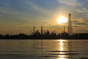 Bangchak Petroleum's oil refinery in Silhouette, beside the Chao Phraya River, Petrochemical industrial with sunrise background in Phra Khanong District, Bangkok, Thailand