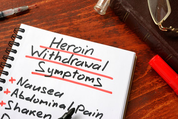 Heroin withdrawal written on a note. Drugs addiction concept.