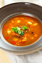 Tomato soup on wooden table, top view