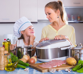 Girl and mom cooking with multicooker.