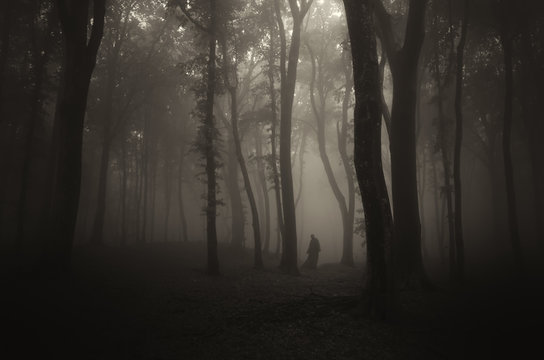 spooky ghostly figure in dark halloween forest