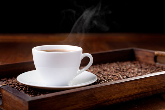 white cup of steaming coffee on a tray