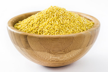 Organic millet seeds in wooden bowl isolated on white background

