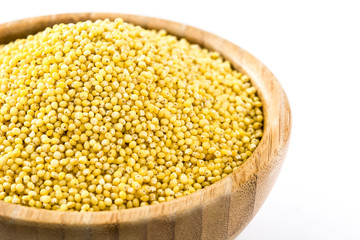 Organic millet seeds in wooden bowl isolated on white background

