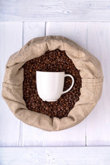 coffee mug in a bag full of coffee beans