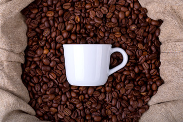 coffee cup in a bag full of coffee beans