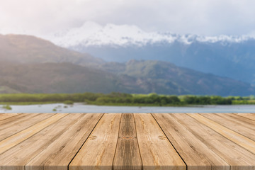 Wooden board empty table in front of blurred background. Perspective brown wood table over blur lake in forest mountain background - can be used mock up for display or montage your products.