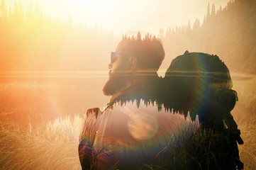 Portrait of stylish bearded man with glasses and tourism backpack.  Double exposure, view on  the...