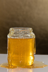 Jar of honey with honey dripping on it