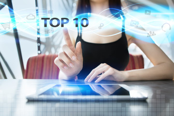 Woman is using tablet pc, pressing on virtual screen and selecting top 10