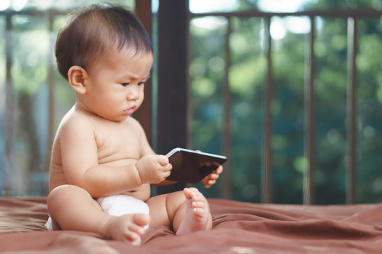 Asian Baby Playing Mobile Phone