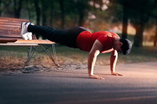 Fitness Man doing a Bench Press Up Outside