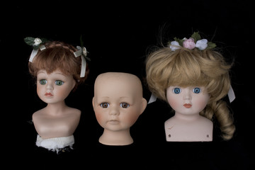 Doll Heads on Black Background