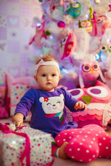 Fototapeta na wymiar The beautiful baby sits near gifts