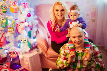 The happinest family sits near christmas tree