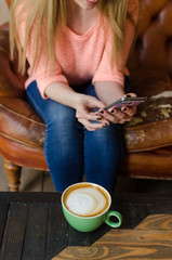 Fototapeta na wymiar Young woman with coffee and phone
