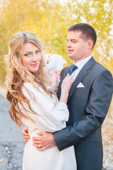 невеста положила руку на плечо жениха. Свадьба осенью. Осенняя свадьба