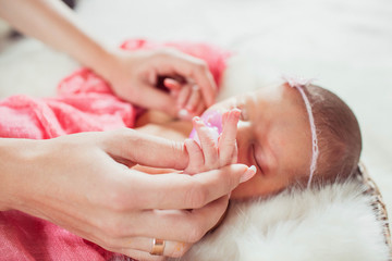 happy mother holds the hand of her newborn baby