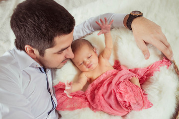 young father  admires his newborn  baby