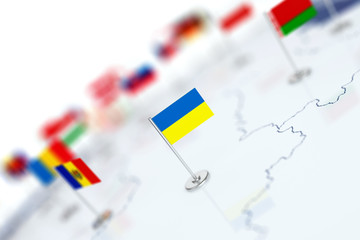 Ukraine flag in the focus. Europe map with countries flags