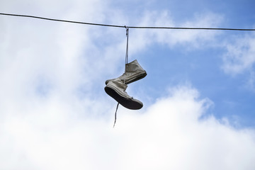 The old sneakers hanging on wires.