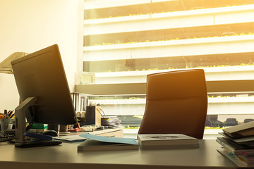 Work desk in office by the window with sun flare