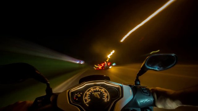 4K pov bike ride timelapse. Night city motorbike ride, selective focus on speedometer.
