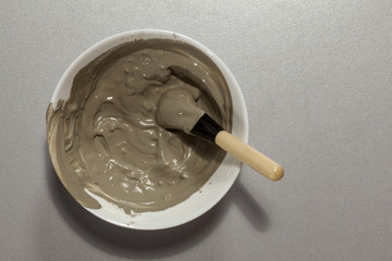 dish with a face mask from green clay