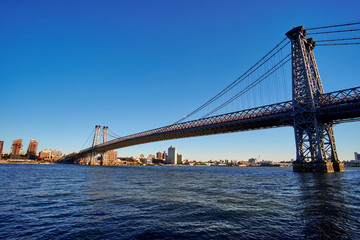 Williamsburg Bridge going over East River from Manhattan to Brooklyn side in a low autumn sun