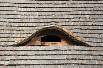 old thatch roof with small roof window