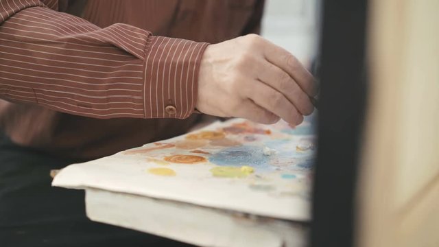 Artist painting with paintbrush. Close-up