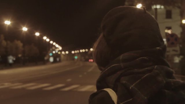 Young woman waiting taxi night city street hyperlapse warm tone shot