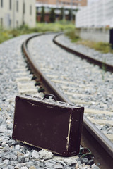 suitcase next to the railroad tracks