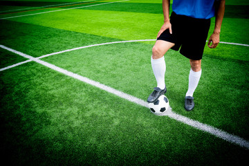 Soccer player ready to play at kick off point in soccer field.
