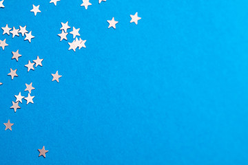 Frame of scatters little silver stars on blue background.