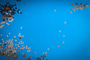 Frame of scatters little silver stars on blue background.