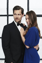 Glamour couple in studio, looking away