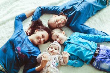 Fototapeta premium parents and their children lying in bed