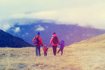 Obraz premium family with two kids hiking in winter mountains