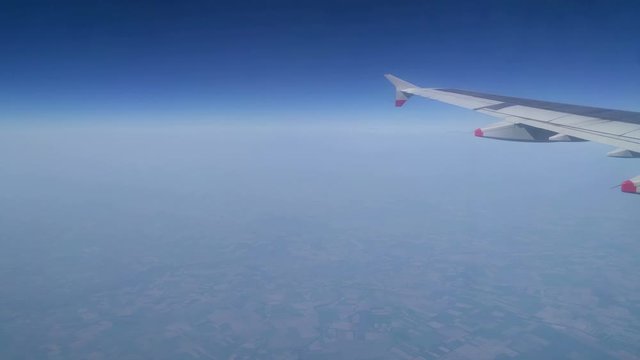 Color footage of an airplane wing while flying.