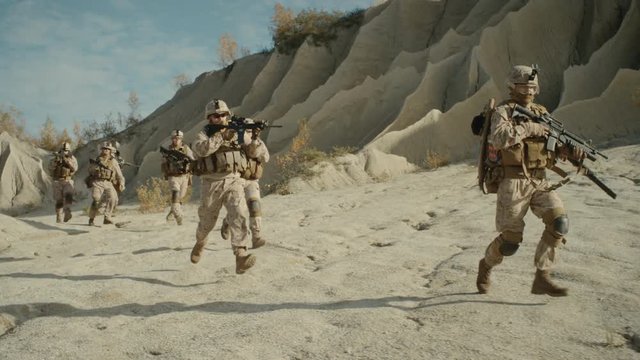  Squad of Fully Equipped, Armed Soldiers Running in the Desert. Show Motion. Shot on RED EPIC Cinema Camera in 4K (UHD).