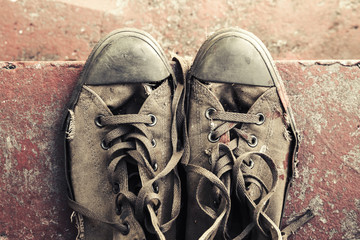Old sneakers stand on concrete stairs