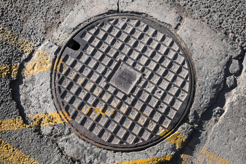 Round metal hatch in urban pavement