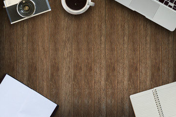 Office desk wood with computer, notebook, camera  and coffee cup concept in wood background.Old camera in wood background.Copy space