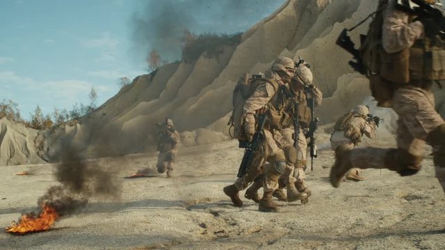 Soldiers Carrying Injured One While other Members of Squad Covering Them During Military Operation in the Desert. Shot on RED EPIC Cinema Camera in 4K (UHD).