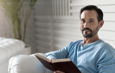 Nice delighted man reading a story