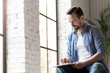 Cheerful creative man involved in drawing