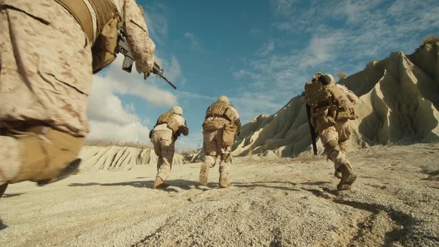  Follow Shot of Squad of Soldiers Running Forward During Military Operation in the Desert. Slow motion. Shot on RED EPIC Cinema Camera in 4K (UHD).