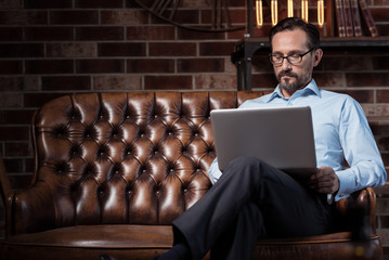 Serious self employed man working on the laptop