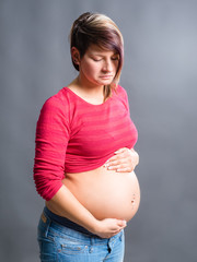 Pregnant woman with stomachache holds her tummy in pain.